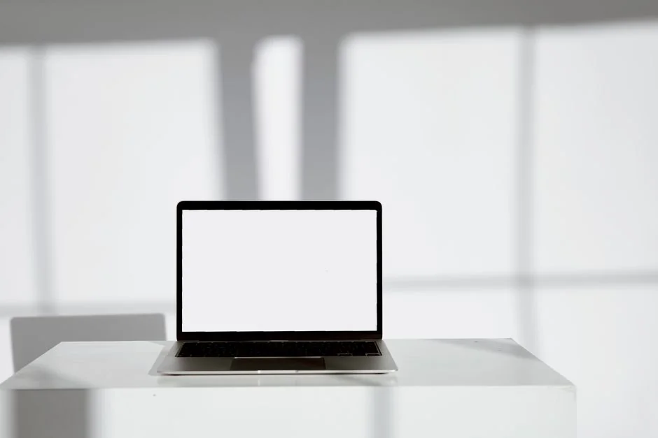 Business professional using a tablet and laptop with a hot drink, concentrating on reviewing digital content.